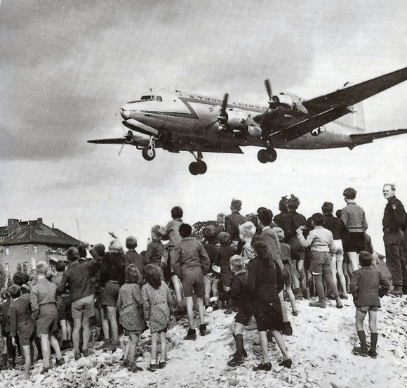 Berliner beobachten die Landung eines Rosinenbombers auf dem Flughafen Tempelhof (1948) Foto: USAF - United States Air Force Historical Research Agency via Cees Steijger Lizenz: Gemeinfrei