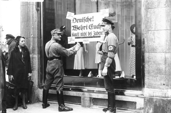 SA-Mitglieder bekleben die Schaufenster eines jüdischen Geschäfts in Berlin oder Oldenburg Foto: Georg Pahl Lizenz: CC BY-SA 3.0 de