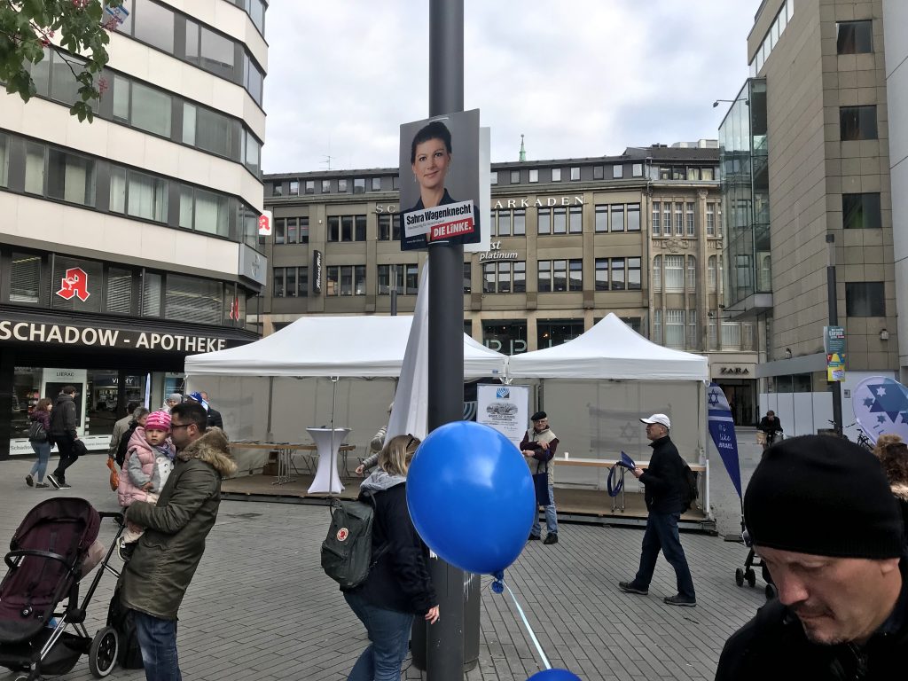 Da kann, beim Israel-Tag in Düsseldorf, nichts schiefgehen: Von oben herab wacht Sahra Wagenknecht über das Geschehen am Schadowplatz; Foto: Peter Ansmann