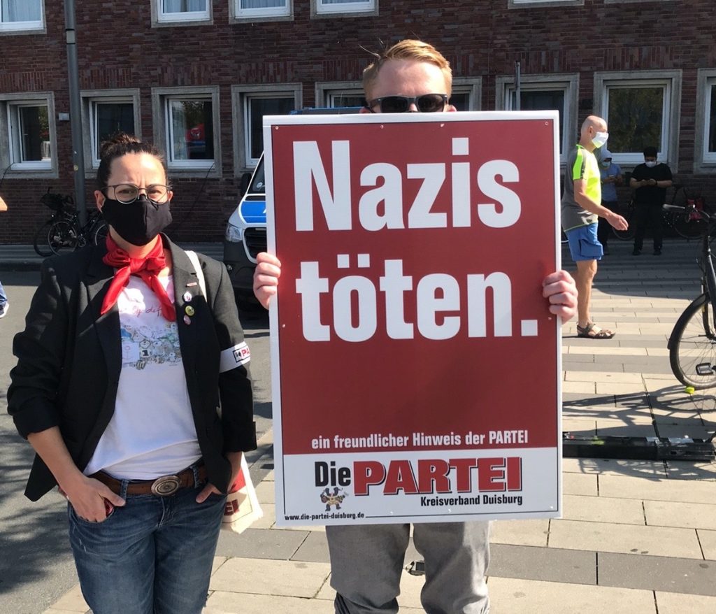 Der "graue Block" der PARTEI Duisburg (Sabine Hampe und Chris Fath) mit "Nazis töten."-Plakaten; Foto: Peter Ansmann