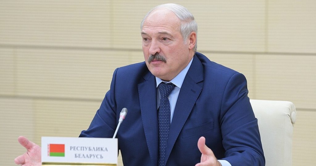 Alexander Lukaschenko bei einem Treffen am 26. Dezember 2017; vor ihm ein Tischschild mit belarussischer Flagge und der Aufschrift „Republik Belarus“.