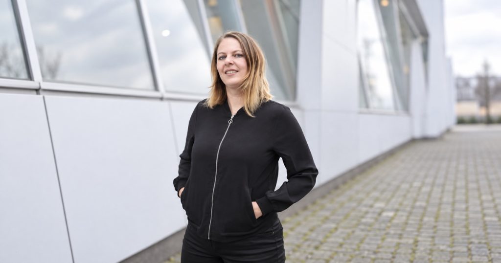 Lea Reisner vor einer modernen Gebäudefassade. Für das Querformat bearbeitetes Foto.
